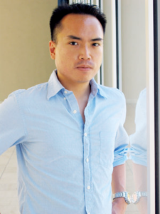 A portrait of a young man with short dark hair and a light blue collar shirt.