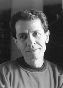 An unsmiling, light skinned, middle-aged man looks slightly to the left of the camera.
