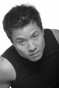 An Asian man looks up into the camera.