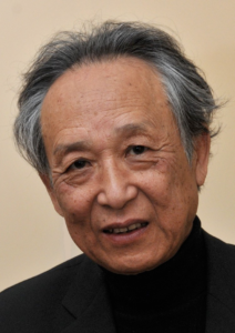 An East Asian man with thinning salt-and-pepper hair smiles at the camera. 